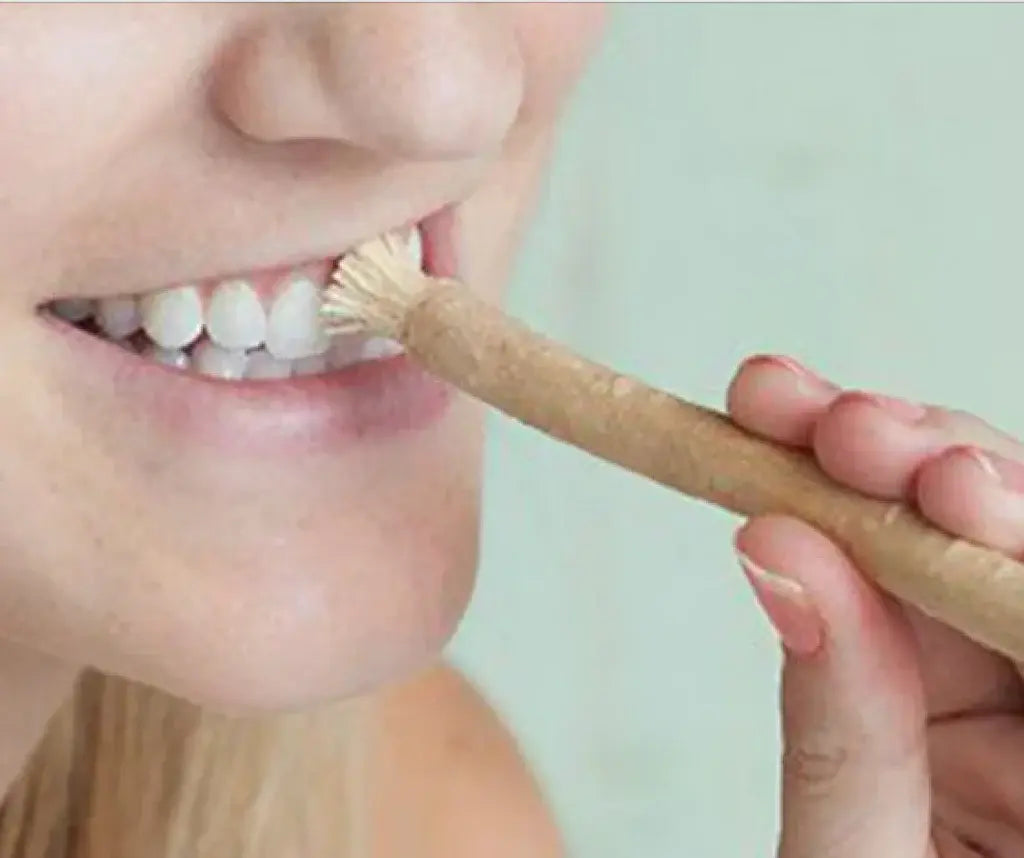 woman brushing teeth with miswak toothbrush